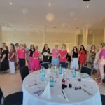 gruppe von Frauen/ Unternehmerinnen stehen in einer Reihe und sind sommerlich gekleidet in Beerenfarben